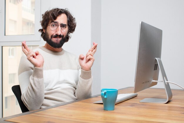 Joven independiente barbudo loco trabajando con su computadora