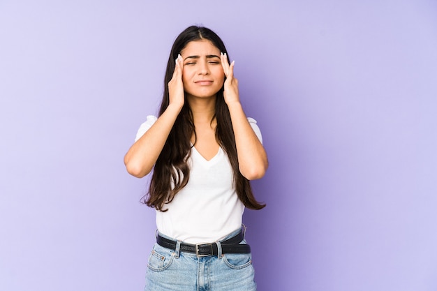 Joven india aislada en la pared púrpura lloriqueando y llorando desconsoladamente.