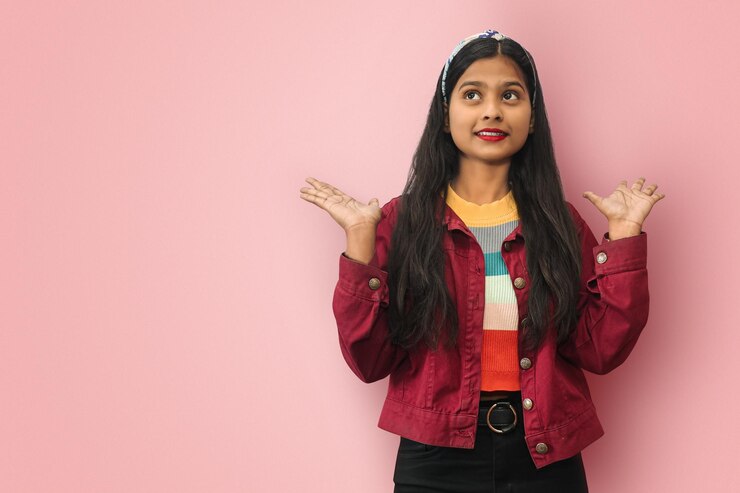 Joven india asiática confundida aislada mirando hacia arriba extendiendo las manos Concepto de pensamiento estratégico y análisis de los hechos Maqueta espacio de copia