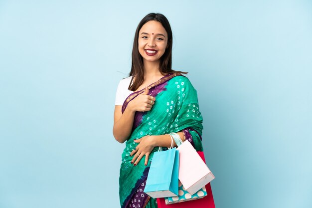 Joven india con bolsas de compras dando un gesto de pulgares arriba