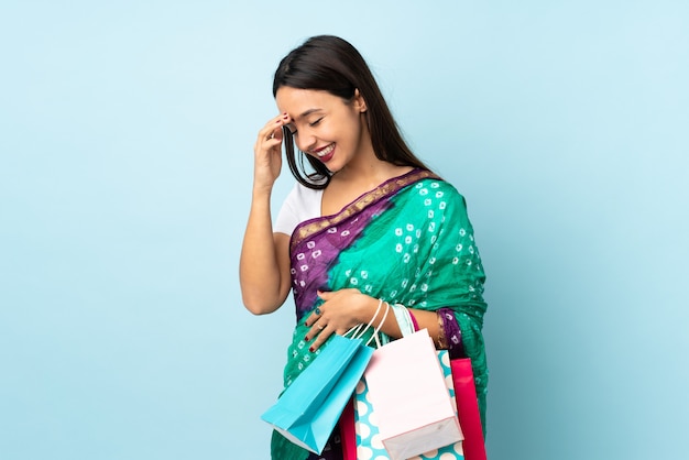 Joven india con bolsas de compras riendo