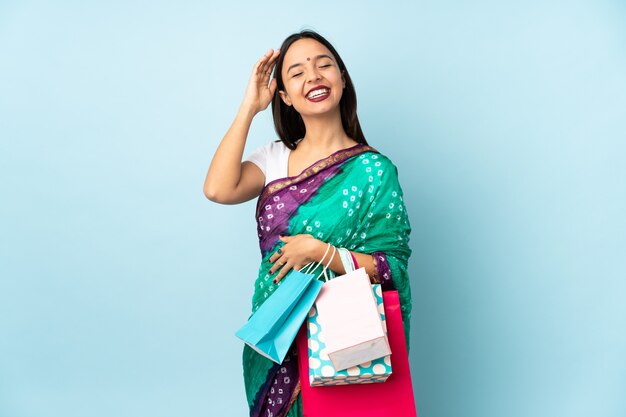 Joven india con bolsas de compras sonriendo mucho