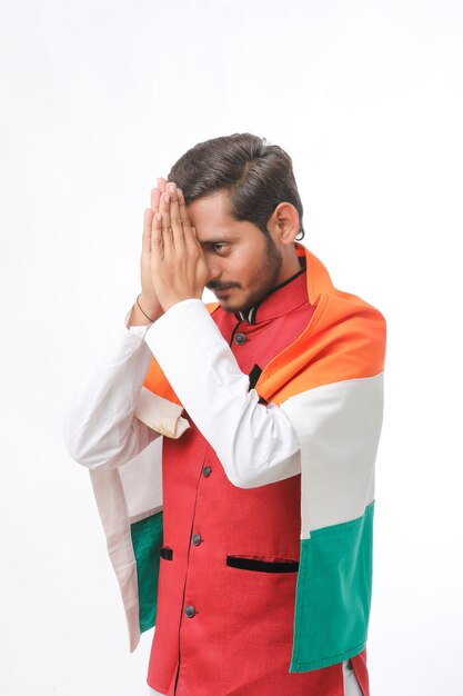 Joven indio con bandera india sobre fondo blanco.