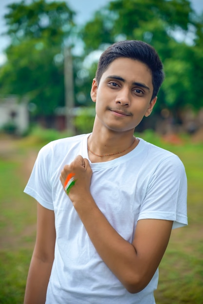 Foto joven indio con la bandera india en su mano