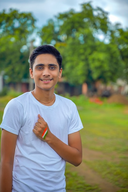 Joven indio con la bandera india en su mano