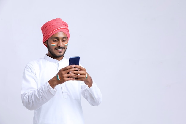 Joven indio celebrando el día de la independencia o el día de la república y con smartphone.