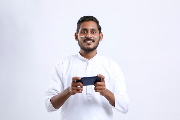 Joven indio celebrando el día de la independencia o el día de la república y con smartphone.