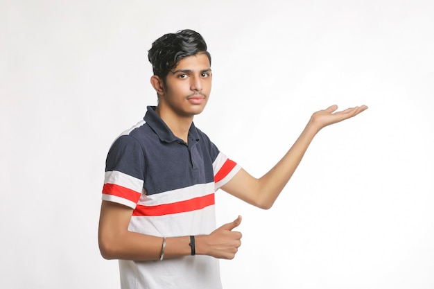 Joven indio dando expresión con la mano sobre fondo blanco.