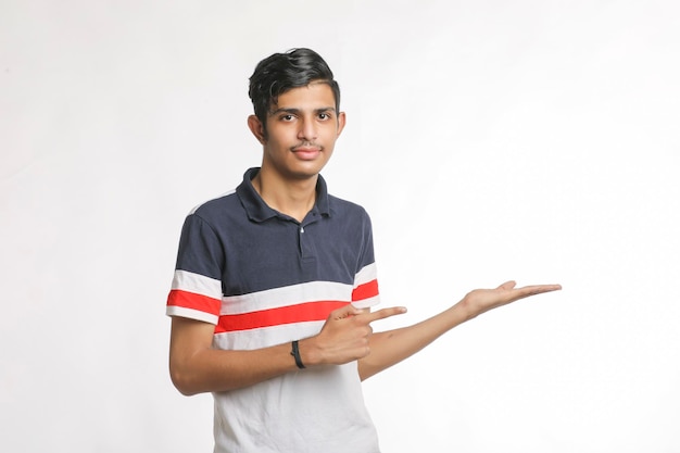 Joven indio dando expresión con la mano sobre fondo blanco.