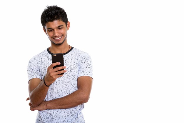 Joven indio feliz sonriendo mientras usa el smartphone