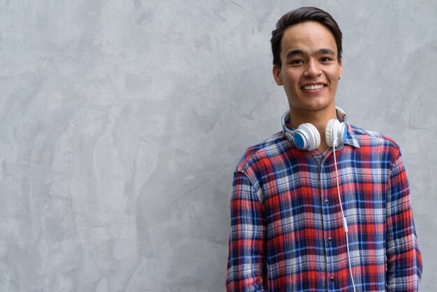 Joven indio guapo contra el muro de hormigón en las calles