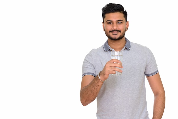 Joven indio guapo sosteniendo un vaso de agua