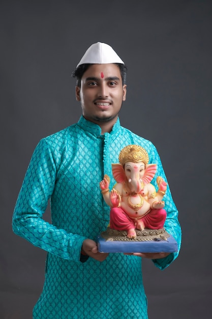 Joven indio con lord ganesha sclupture. celebrar el festival de ganesha.