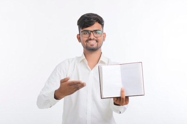 Joven indio mostrando diario sobre fondo blanco.