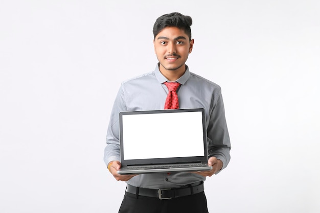 Joven indio mostrando la pantalla de un portátil con fondo blanco.