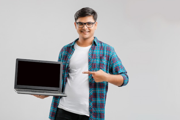 Joven indio mostrando la pantalla del portátil