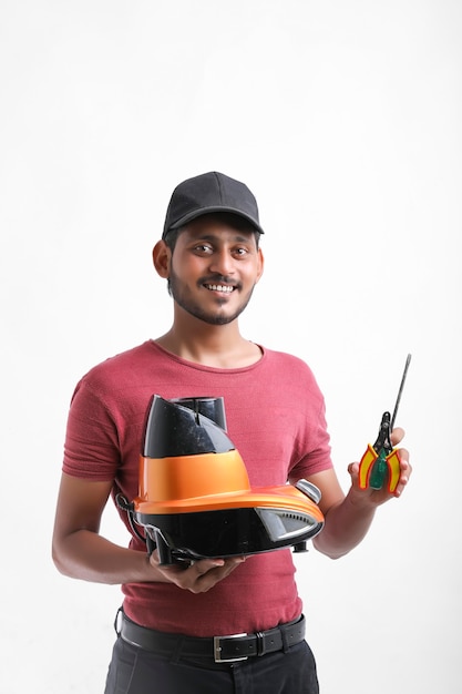 Foto joven indio que repara utensilios de cocina electrónicos con herramientas y batidora en la mano