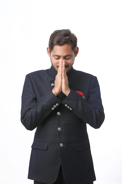 Joven indio con ropa tradicional y dando namaste o gesto de bienvenida.