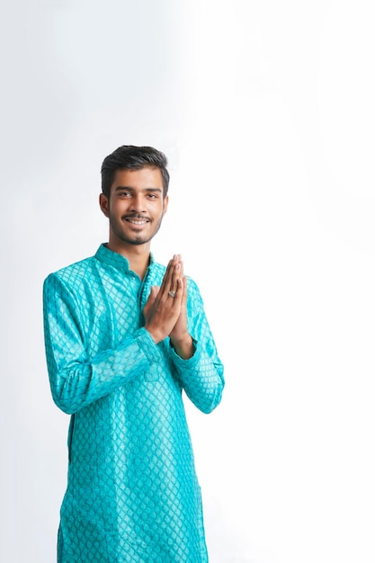 Joven indio en ropa tradicional y dando namaste o gesto de bienvenida