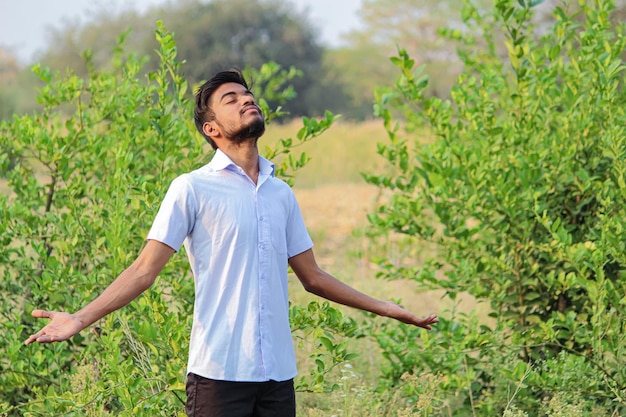 Joven indio salta en el aire en el campo de la agricultura