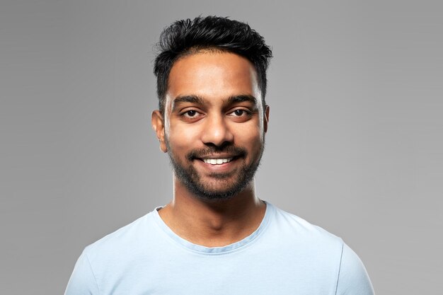 Foto joven indio sonriente sobre un fondo gris