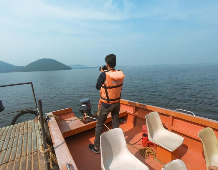 Joven indio tomando fotografías desde el barco