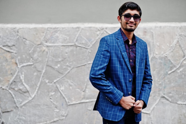 Joven indio con traje azul y gafas de sol posó al aire libre