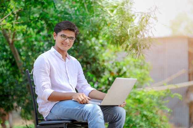 joven indio usando laptop, trabajando en laptop