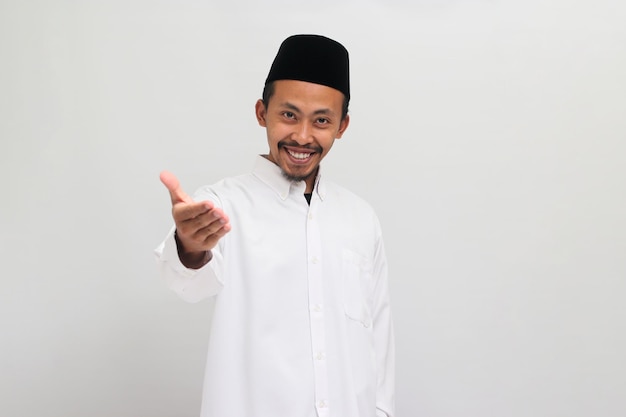 Un joven indonesio confiado está listo para estrechar la mano aislado sobre fondo blanco.