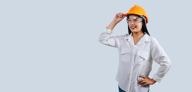 Joven ingeniera con casco amarillo y postura de sonrisa encantadora