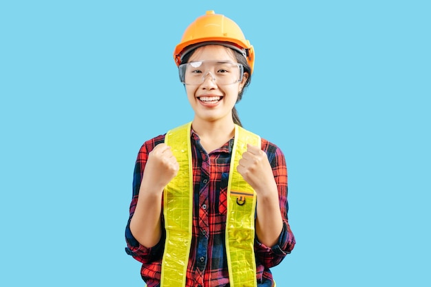 Joven ingeniera con casco de pie con el pulgar hacia arriba