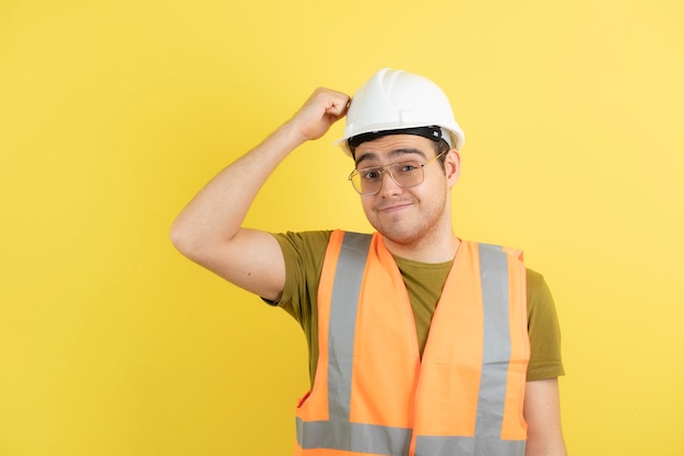 joven ingeniero en casco blanco de pie y posando.