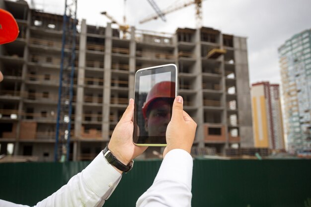 Joven ingeniero de construcción en obra con tableta digital