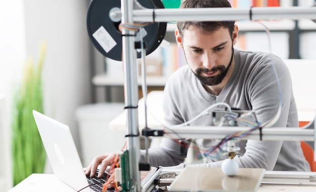 Foto joven ingeniero diseñador que utiliza una impresora 3d en el laboratorio y estudia un concepto de innovación y tecnología de prototipo de producto