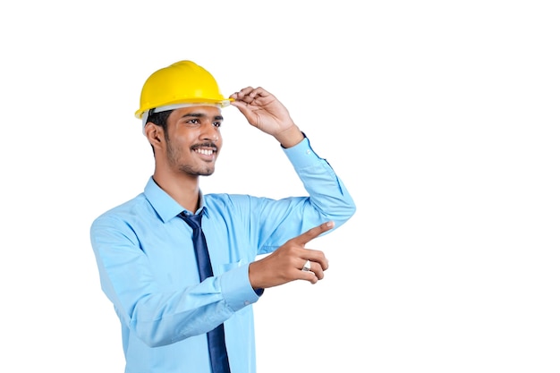 Joven ingeniero indio con casco de color amarillo y dando un gesto exitoso.