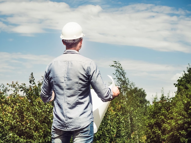 Joven ingeniero con planes en el parque.