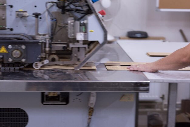 joven ingeniero positivo frente a la producción de muebles en la máquina de corte de madera