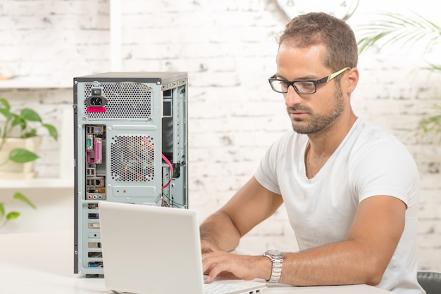 Foto joven ingeniero reparó una computadora