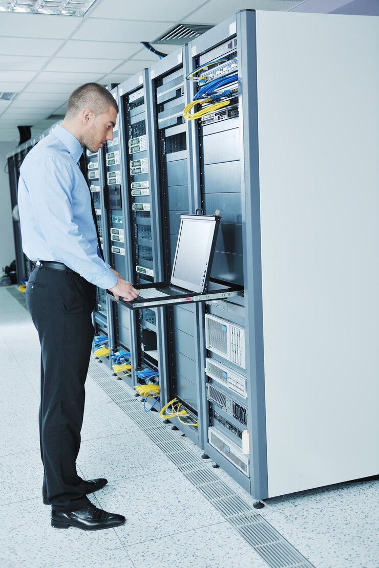 Foto joven ingeniero en la sala de servidores del centro de datos
