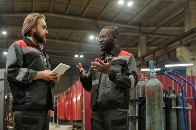 Joven ingeniero serio mirando a su colega afroamericano