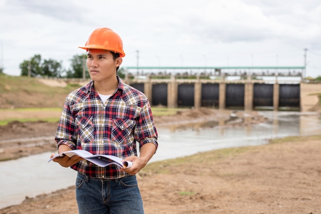 Joven ingeniero trabajando en el sitio en la presa