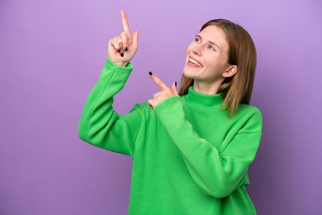 Joven inglesa aislada de fondo morado señalando con el dedo índice una gran idea