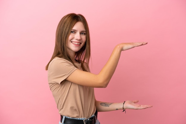 Joven inglesa aislada de fondo rosa con espacio de copia para insertar un anuncio