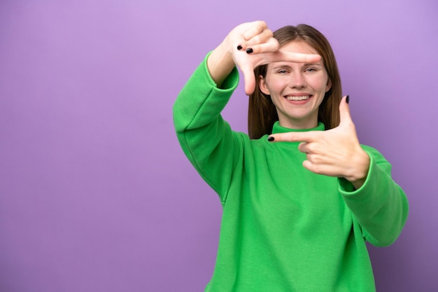 Foto joven inglesa aislada sobre fondo púrpura enfocando la cara símbolo de encuadre