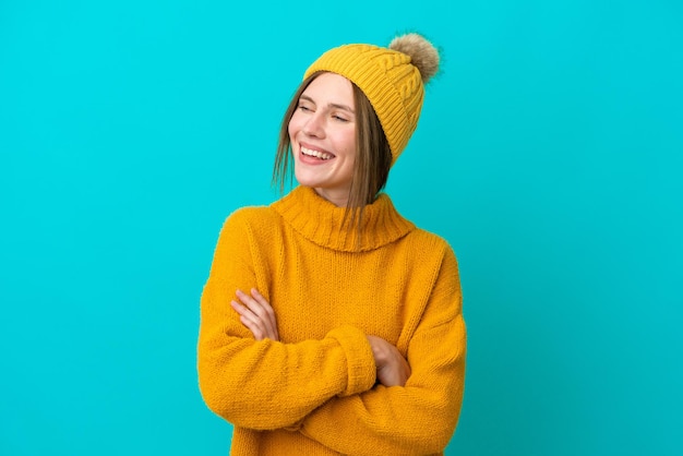 Joven inglesa con chaqueta de invierno aislada de fondo azul feliz y sonriente