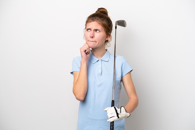 Joven inglesa jugando al golf aislada de fondo blanco con dudas y pensando