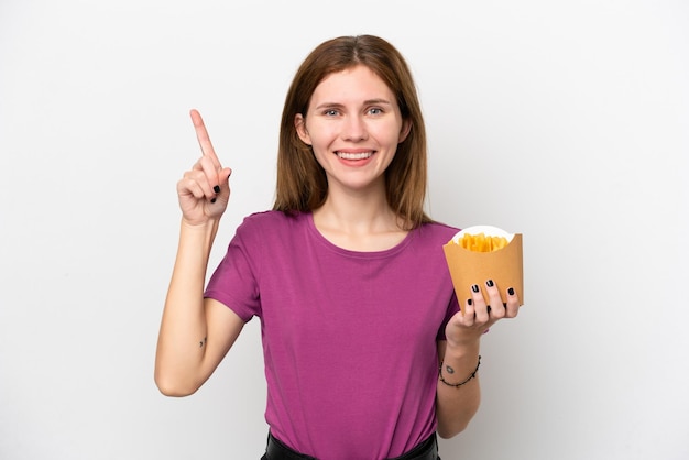 Joven inglesa sosteniendo patatas fritas aisladas de fondo blanco señalando una gran idea