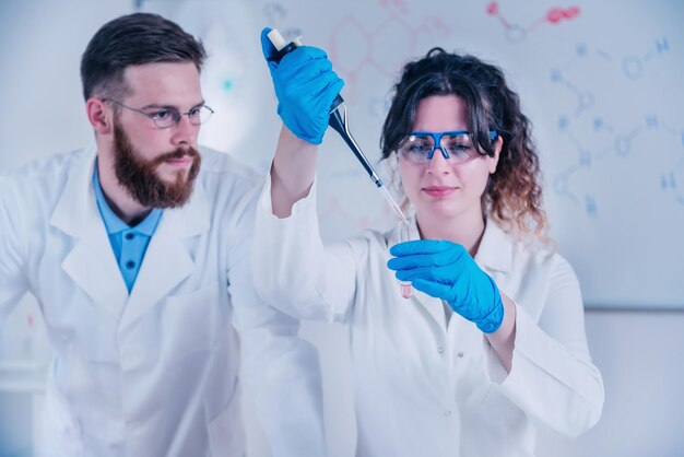 Foto joven investigadora con un gotero y un tubo de ensayo