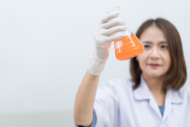 Una joven investigadora, médica, científica o asistente de laboratorio que trabaja con tubos médicos de plástico para investigar y examinar experimentos científicos en un laboratorio moderno. Educación foto de stock