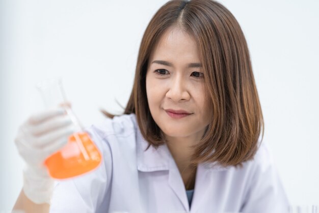 Una joven investigadora, médica, científica o asistente de laboratorio que trabaja con tubos médicos de plástico para investigar y examinar experimentos científicos en un laboratorio moderno. Educación foto de stock